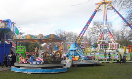 John Green's toy ride and planes at one of the entrances into Norwich Easter Fair in the shadows of Shaun-James Wesley's matterhorn and Mark Thurston Jnr's Chaos freak out.