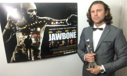 Luke next to the Jawbone poster with his National Film Awards trophy for Best Action Scene.